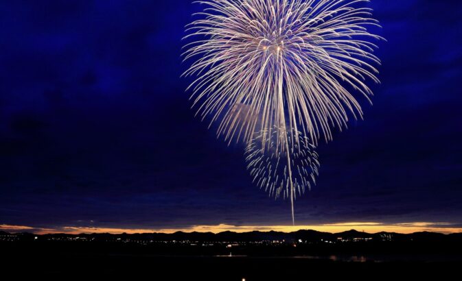 Fogo-de-artifício no céu noturno por cima de uma cidade